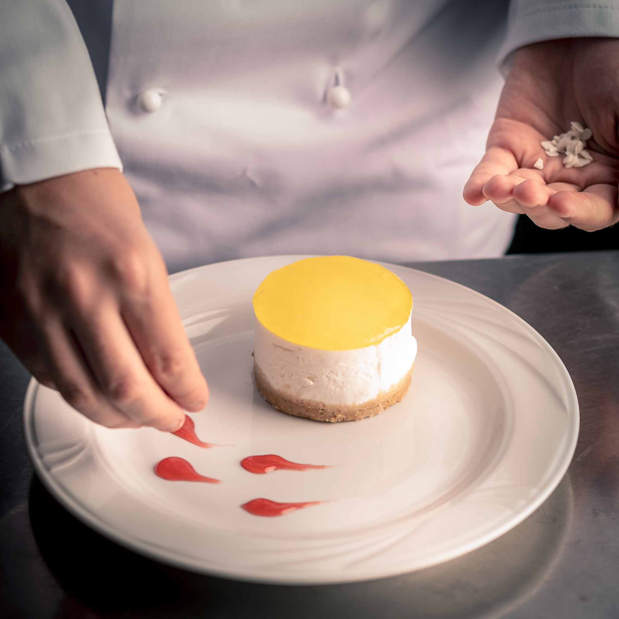 Chef plating a cheesecake dessert