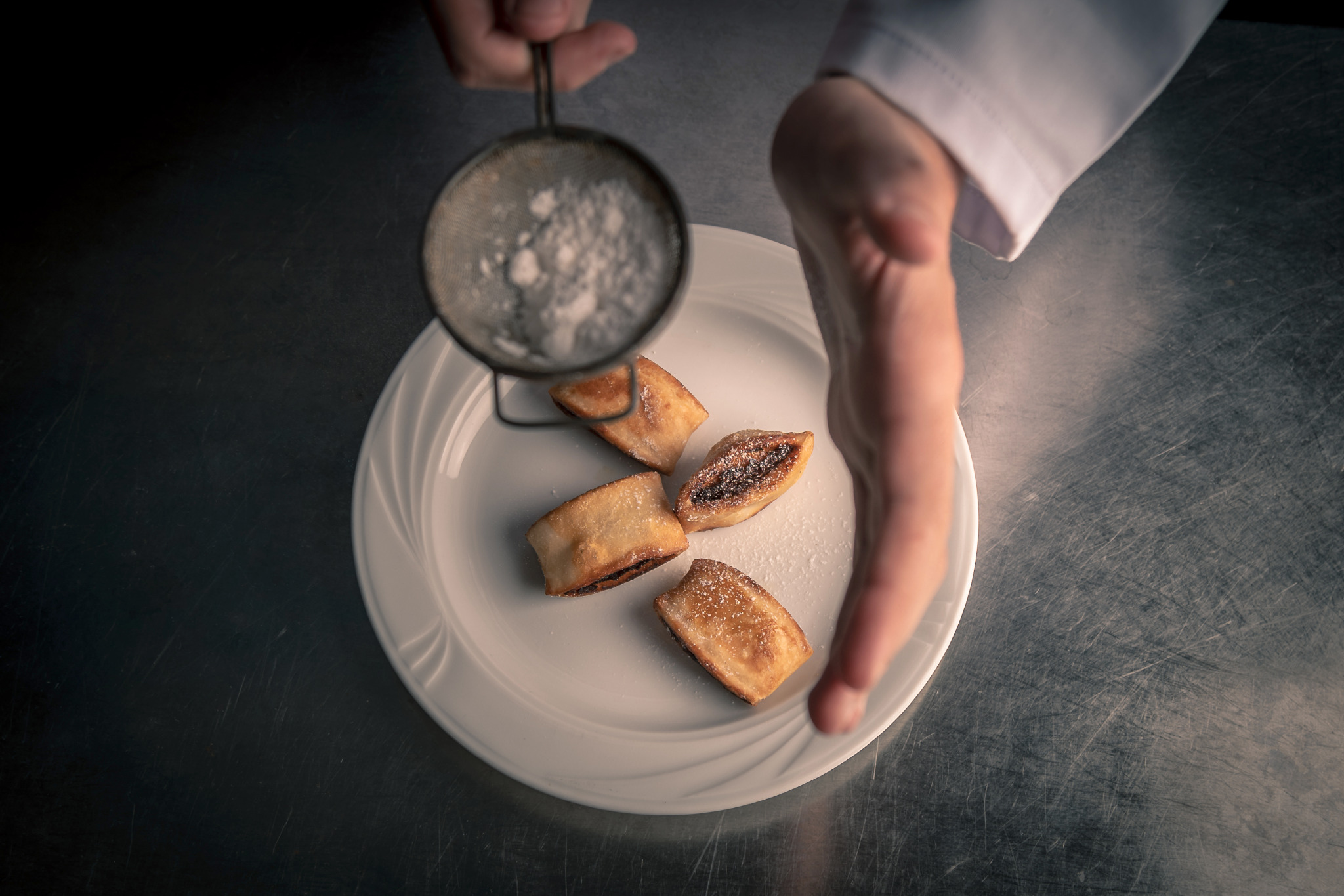 Chef dusting pastries with sugar